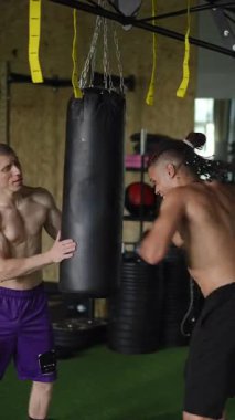 Bir kum torbasını ve spor salonunda kendini adamış sporcuları içeren yoğun bir boks antrenmanına giriyorsun.