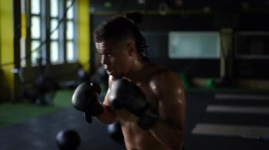 Kendini adamış bir sporcu yoğun bir şekilde antrenman yapar, rekabetçi bir boks ortamında bağlılığını ve gücünü gösterir.