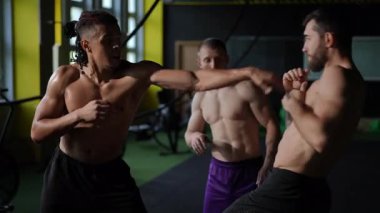 Yetenekli atletler arasında dövüş sanatları tekniklerini sergileyen ve mükemmelliğe odaklanan bir eğitim oturumu.