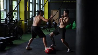 Spor salonunda, kendini işine adamış iki sporcu yoğun bir şekilde antrenman yapar. Odaklanma, çeviklik ve istisnai hareketler ve stratejiler sergilerler.