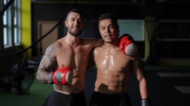 İki formda boksör yoğun eğitimden sonra, atletizm, yetenek ve arkadaşlıklarını sergileyerek mutlu poz verirler.