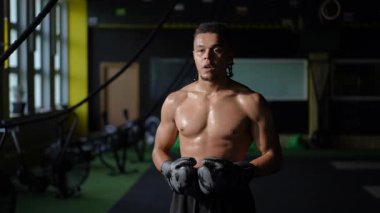 Bir boks salonunda, bir atlet yetenek ve uygunluğu geliştirmek için antrenman yaparken güç, kararlılık ve odaklanma gösterir.