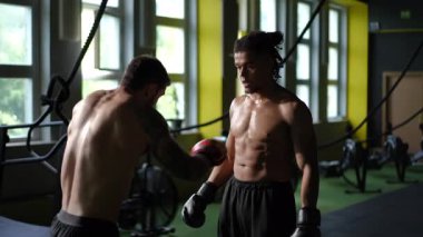 İki kendini adamış boksör, ringde yoğunluklarını ve atletizmlerini sergileyerek odaklanmış bir antrenman seansına giriyorlar.