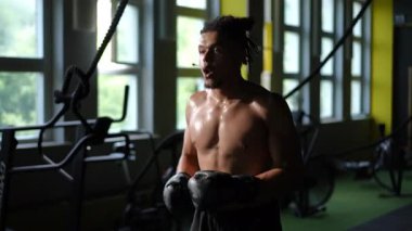 Kendini adamış bir sporcu, yapılandırılmış bir spor salonunda boks becerilerini ustalıkla geliştirir.