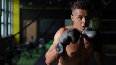 Bir spor salonundaki yoğunluğu ve sarsılmaz odağı kapsayan çekici bir boks antrenmanı deneyimleyin.