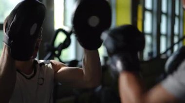 Hareketli ve hareketli bir spor salonunda olağanüstü ayak ve teknikleri vurgulayan yoğun bir boks antrenmanı.