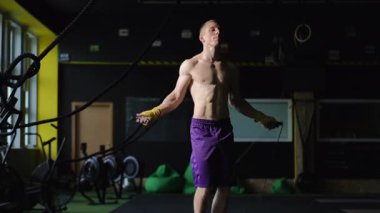Modern bir spor salonunda güçlü ip egzersizleri yapan fiziki olarak fit bir birey.