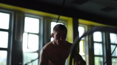 Son derece tutkulu bir sporcu, savaş iplerini kullanarak son derece güçlü ve yoğun bir eğitim seansına katılıyor.