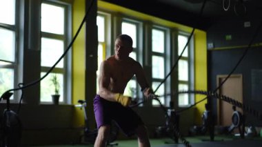 Son derece odaklanmış ve kendini işine adamış bir sporcu modern bir spor salonunda yoğun bir ip egzersizi yapıyor.