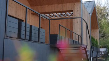 Bu çağdaş tasarım, şık, modern siyah aksanlarla tamamlanmış güzel bir ahşap cephe sergiliyor.