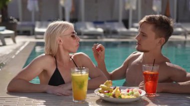 Rahatlatıcı ve lezzetli meyvenin yanı sıra havuz kenarında ferahlatıcı içecekler güzel, güneşli ve canlı bir ortam.
