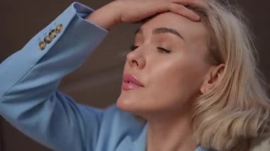 Zarif ve zarif bir yakın plan, kendine güvenen bir kadın şık mavi bir ceket giyiyor, güzelliğini sergiliyor.