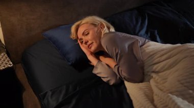 Büyüleyici ve canlı sahneler, yatakta yavaşça uyanan bir kadının çok çeşitli duygular yaşadığını gösteriyor.