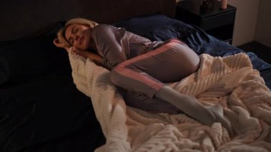 Yumuşak, rahat pijama giymiş bir kadın, sıcak ve rahat bir gece geçirmekten zevk alır.