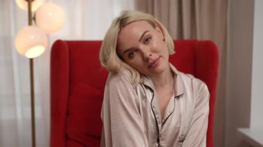 Zarif ipek pijamalı bir kadın samimi bir ortamda sevgi dolu jestler sergiliyor, sıcaklık ve şefkat uyandırıyor.