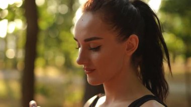 Genç bir kadın, serin bir su içerek kendini ferahlatırken çarpıcı güzellikten zevk alır.