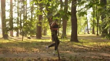 Bir kadın dingin ve huzurlu bir ormanda enerjik bir şekilde koşar, hem doğa hem de spor yolculuğunun tadını çıkarır.