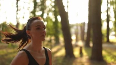 Bir kadın güzel bir ormanda mutlu bir şekilde koşar, doğanın tadını çıkarır büyüleyici günbatımında güzelliği sersemletir