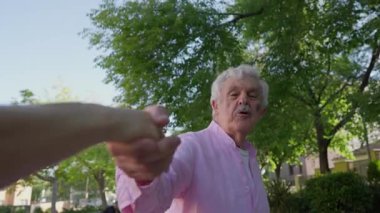 Madrid 'li hayat dolu emekli bir adam bir kadının elini tutuyor ve güneşli bir parkta şehrin güzelliğini paylaşmak için onu heyecanla takip etmesini istiyor..
