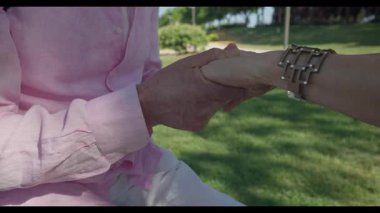 Madrid 'li yaşlı bir adamın yeşil bir parkta otururken nazikçe bir kadının elini tutması, sonraki yaşamdaki duygusal bağ, güven ve sevgiyi sembolize ediyor..