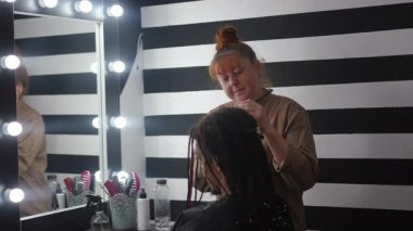 Yetenekli bir kuaför şık, modern bir salonda şık ve zarif bir tasarıma ustalıkla renk katar.