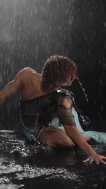 Büyüleyici bir dans gösterisi, yağmurla ıslanmış bir ortamda, sanatsal ve zarafetle güzelce çekilir.