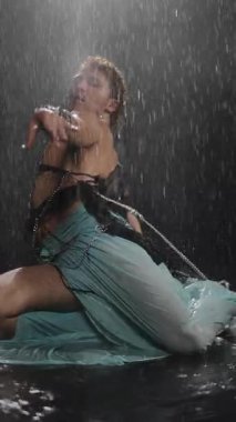 Yağmur altında duygu ve hareketin çarpıcı bir tasviri, sanatsal ifade ve vücut dinamikleri sergileniyor.