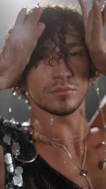 Büyüleyici ve karizmatik bir modelin dinamik yakın çekimleri yağmurun altında zarifçe poz veriyor, duygu ve stil gösteriyor.