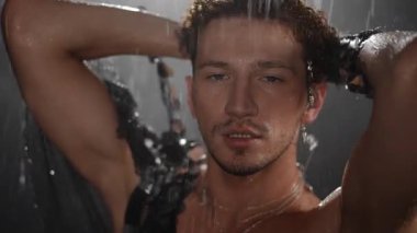 Yağmura yakalanmış bir adamın büyüleyici ve görsel olarak çarpıcı tasviri, ham duyguları güçlü bir şekilde gözler önüne seriyor.