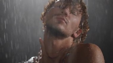 Düşen suyun altında, derin duyguları ve kişisel stili vurgulayan bir modelin çarpıcı yakın çekimleri