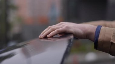 Bir insan nazikçe arabanın pürüzsüz yüzeyine dokunur, derin bir nostalji ve bağlantı hissi uyandırır.