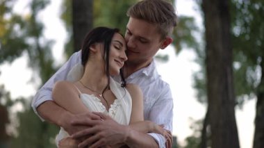 Sevgi dolu bir çift, doğayla çevrili huzurlu ve güzel bir doğal ortamda romantik bir kucaklaşmayı paylaşıyor.