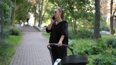 Huzurlu bir park ortamında, genç bir kadın, bir bebek arabasını iterken tesadüfen telefonuyla sohbet ediyor.