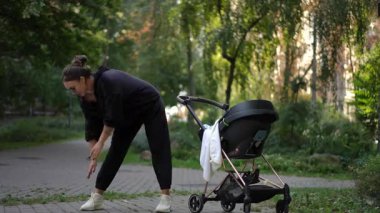 Huzurlu bir park ortamında bebek arabasıyla ilgilenirken bir anne hafif bir gerinme yaşar.