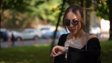 Modaya uygun genç bir kadın güneşli gününün tadını çıkarıyor, şık kıyafetini ve kendine güvenini sergiliyor.