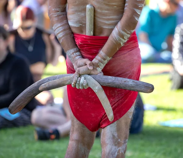 Australian Aboriginal culture, human hands are holding boomerangs, the ritual rite at the community event, symbol of indigenous culture and traditions