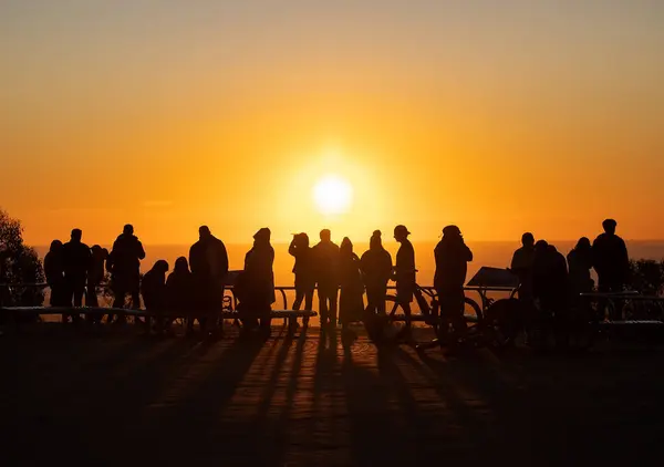 Gün batımındaki insan siluetleri ışık, derin gölgeler, akşam turuncu güneşi