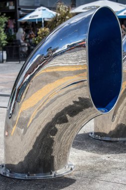 Parlak metal buharlı gemi borusu, şehrin liman sokaklarının dekorasyon unsuru endüstriyel şehir yapıları, ilginç yansımaları.