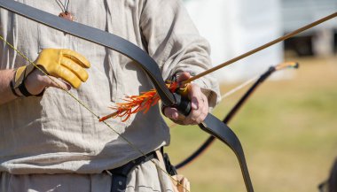 Ortaçağ okçuluk ekipmanları, bir adamın elinde ok ve yay. Ortaçağ panayırı. Yüksek kalite fotoğraf