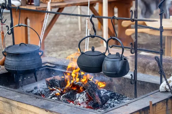 İki siyah metal çaydanlık ve kazan, kamp ateşinin üzerinde asılı duran tencere, yakın plan, kamp. Yüksek kalite fotoğraf