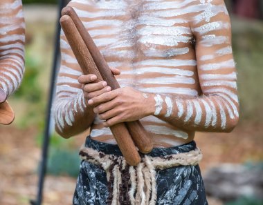 Avustralya 'daki yerli uzlaşma topluluğunun bir etkinliğinde, Avustralya' daki hoşgeldin ayini için insan eli alkış çubukları tutuyor.