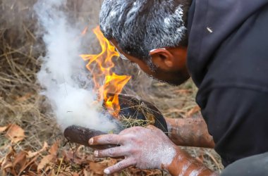 Human hands with green branches, wooden ritual dish and fire, Australian aboriginal smoking ceremony, ritual rite at an indigenous community event. Welcome to the country ceremony.  clipart