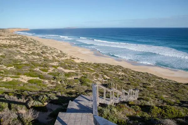 Güzel deniz manzarası, mavi gökyüzü ve bulutlar, sahile giden ahşap merdivenler. Yüksek kalite fotoğraf