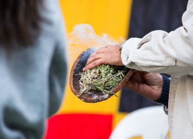 Australian Aboriginal Ceremony, man hand with green branches and flame, start a fire for a ritual rite at community event in South Australia clipart