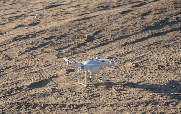 stock image A small drone stands on the sand, new photography technologies. High quality photo