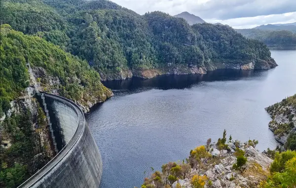 Tazmanya 'daki Gordon Barajı, engebeli uçurumlarla çevrili etkileyici bir beton yapı ve ıssız bir yerde sakin bir göl. Yüksek kalite fotoğraf