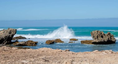 Keskin kıyı kaya oluşumları ve turkuaz okyanus dalgaları Güney Avustralya 'nın engebeli kıyı şeridinde buluşuyor.