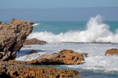 Keskin kıyı kaya oluşumları ve turkuaz okyanus dalgaları Güney Avustralya 'nın engebeli kıyı şeridinde buluşuyor.
