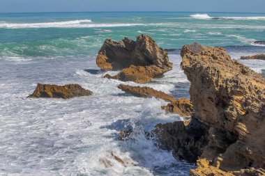 Keskin kıyı kaya oluşumları ve turkuaz okyanus dalgaları Güney Avustralya 'nın engebeli kıyı şeridinde buluşuyor.
