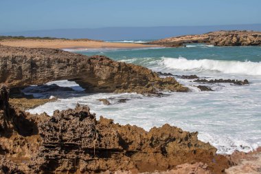 Keskin kıyı kaya oluşumları ve turkuaz okyanus dalgaları Güney Avustralya 'nın engebeli kıyı şeridinde buluşuyor.